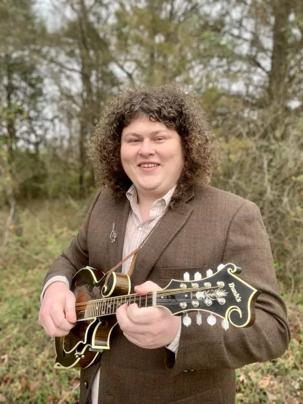 Daniel David holding an F-style mandolin outdoors