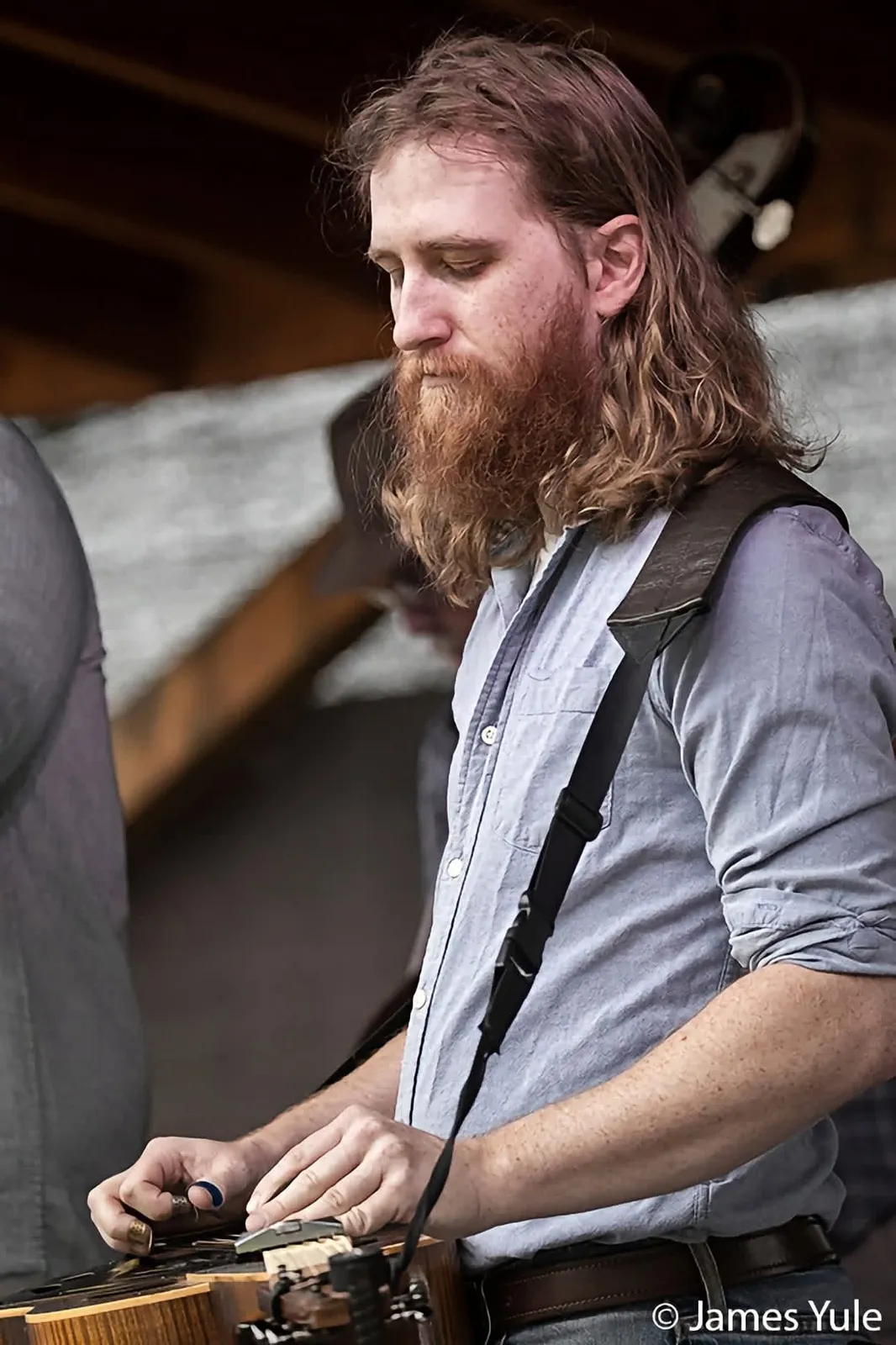 Adam Bachman playing resonator guitar on stage