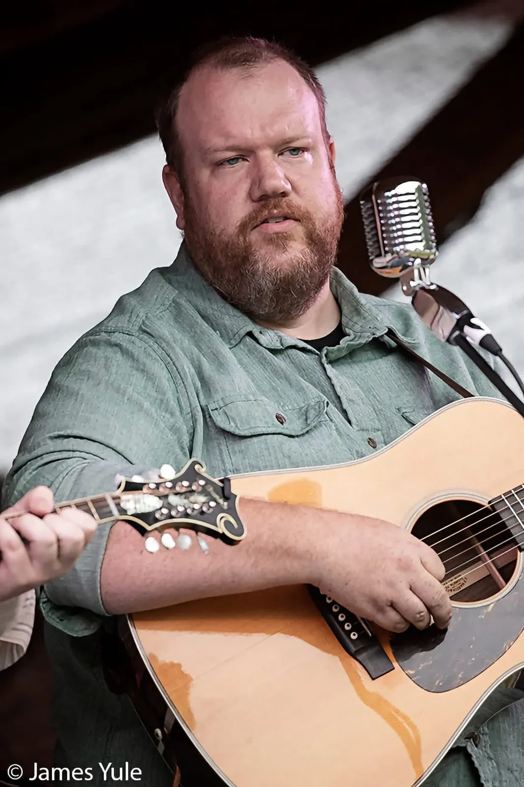 Justin Smith at the microphone with his guitar