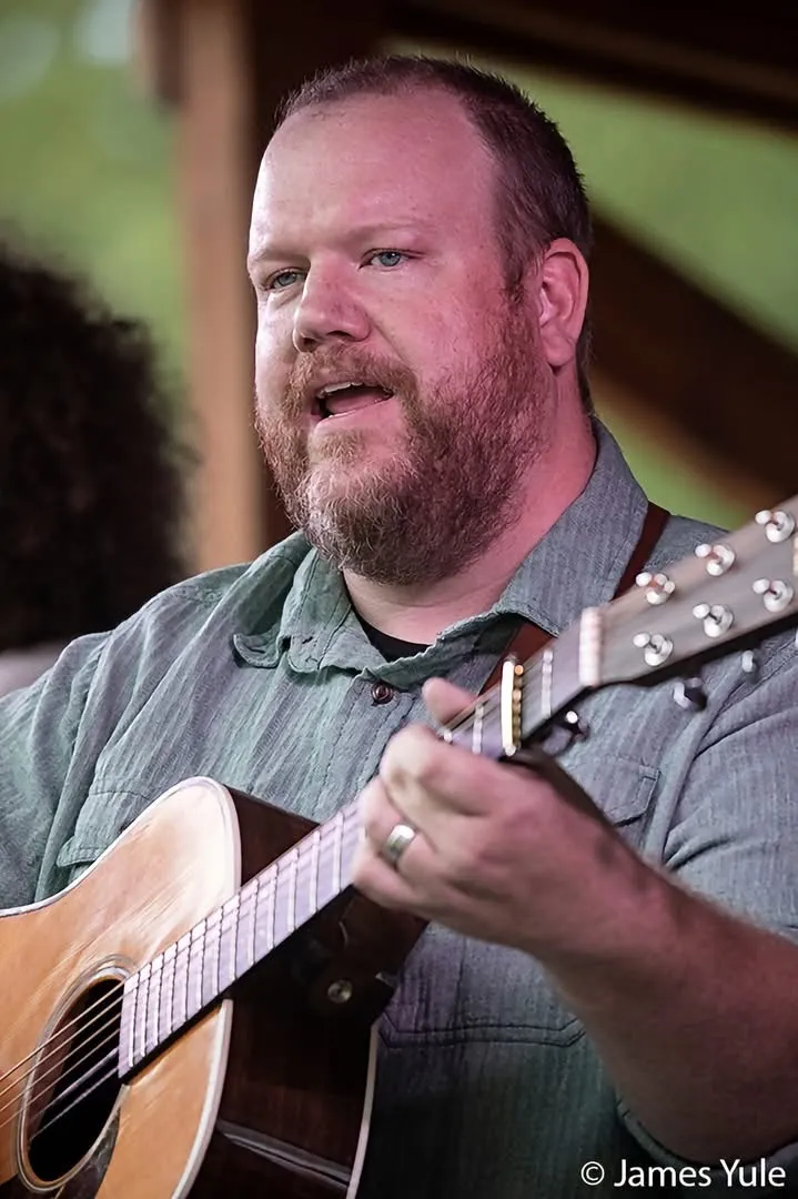 Justin Smith singing and playing guitar